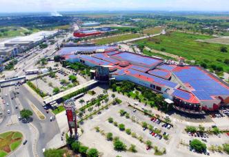 Aerial view shopping center mall red roof top solar panels parking lot